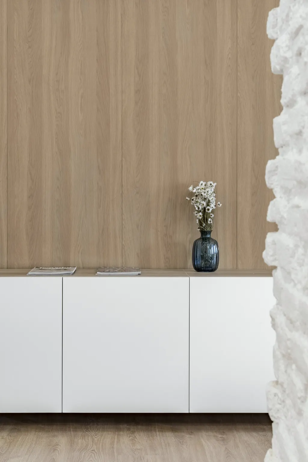 Vivienda BM123: mueble blanco, panel de roble y piedra