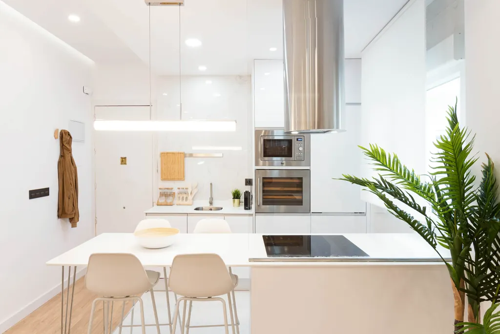 Vivienda T68: cocina blanca con isla y taburetes