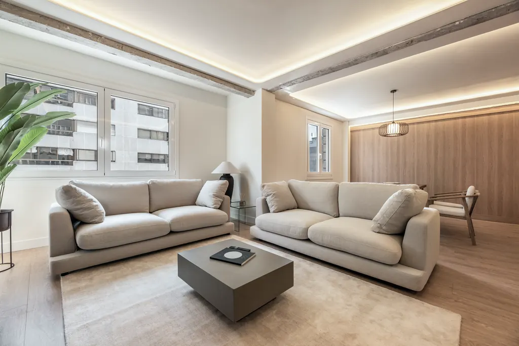 Vivienda V48: salón con dos sofás y viga vista